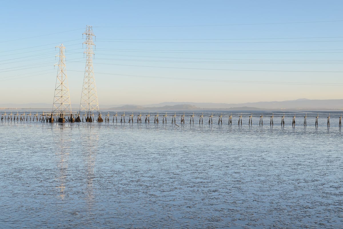 A levee trail beside the water in the Baylands, with the foothills beyond
