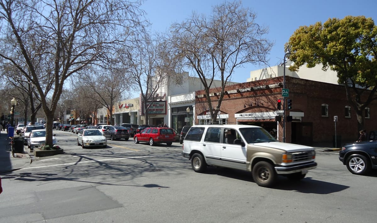 A tree-lined block of downtown shops and a theatre marquee